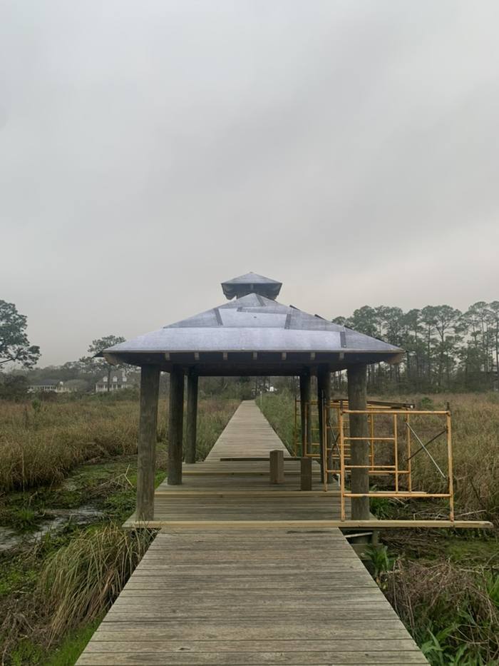Covered sitting area with a metal roof on the marsh pier