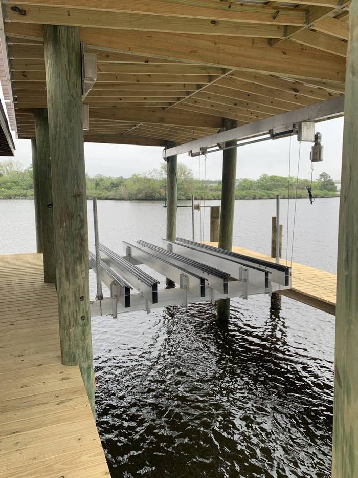 Lift bunks hanging under a boathouse roof over the water