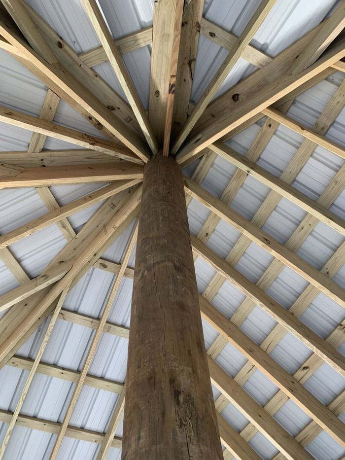 Looking up at the roof framing of a hip-roof boathouse